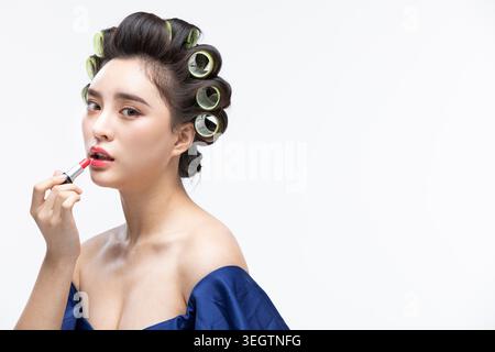 Eine junge Frau trägt Lippenstift in einem Schönheitssalon auf. Stockfoto