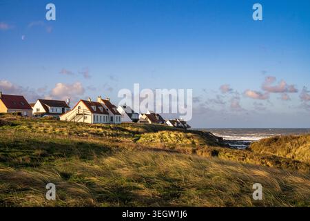Malerischer Blick auf Audresselles Dorf mit seinen typischen weißen Häusern und roten Dächern mit Blick auf das Meer. Das Foto zeigt beleuchtete grasbewachsene Dünen Stockfoto