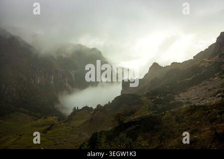Strada delle 52 Gallerie, Italien - 07.10.2024: Geheimnisvoller Blick auf die majestätischen Berggipfel, teilweise von dicken Wolken und starkem Nebel verdeckt. Stockfoto