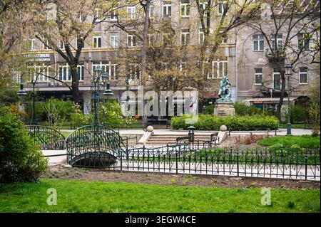 Krakau, Polen - 11. April 2026: Spaziergang in einem Park in Krakau Polen mit einer Statue und einer Brücke in der Szene Stockfoto