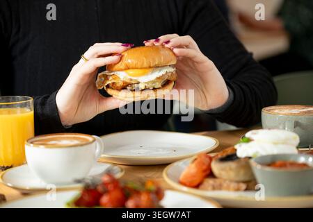 Genießen Sie morgens ein gemütliches Café mit einem herzhaften Frühstückssandwich Stockfoto