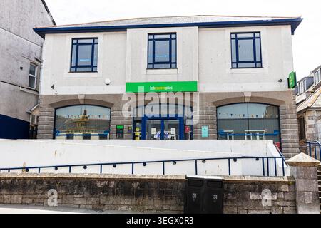 Außenansicht des Jobcenter Plus-Gebäudes in Newquay, Cornwall, mit grüner Beschilderung über dem Eingang und blau gerahmten Glastüren Stockfoto