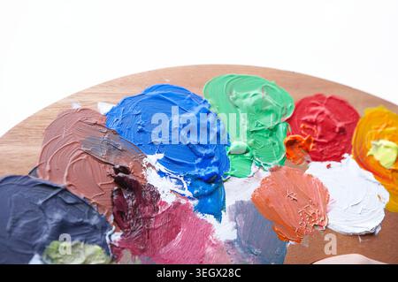 Eine Nahaufnahme einer Holzpalette mit einer Vielzahl von bunten Farbmustern. Stockfoto