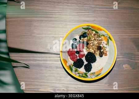 Gesunder Smoothie Schüssel mit Beeren und Müsli auf rustikalem Holztisch Stockfoto