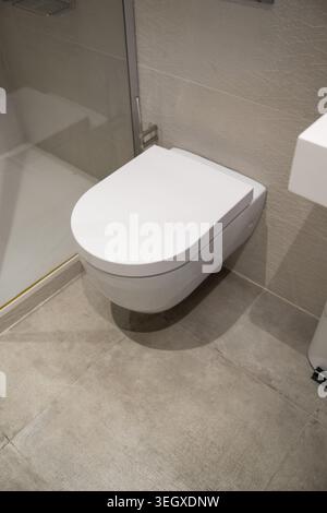 Modernes Badezimmer mit moderner Toilette zur Wandaufhängung, minimalistischem Design, hygienischen Oberflächen und effizienter Raumnutzung Stockfoto