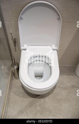 Moderne weiße Keramik-Toilette mit erhöhtem Sitz in einem sauberen und minimalistischen modernen Badezimmer mit Schwerpunkt auf Hygiene, Sanitär und Toiletten Stockfoto