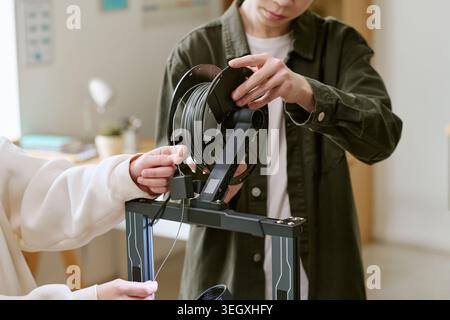 Teenager laden Filament auf 3D-Drucker für das MINT-Lernen Stockfoto