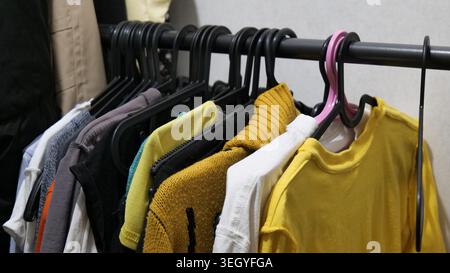 Bunte Kleidung auf hängenden Racks im Store Stockfoto