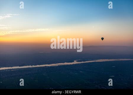 Heißluftballon über dem Nil bei Sonnenaufgang, Luxor, Ägypten Stockfoto