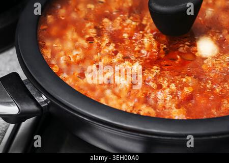 Hausgemachte Spaghetti-Sauce, die im Mehrkochfeld gekocht wird. Warme Pasta-Mahlzeit und traditionelle italienische Küche im Innenbereich. Stockfoto