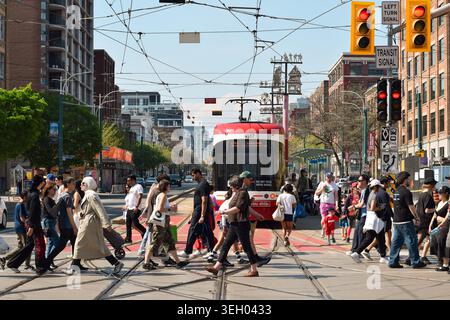 Toronto, Ontario, Kanada - 17. Mai 2026: Fußgänger kreuzen an der Kreuzung von Spadina Avenue und Queen Street in der Innenstadt von Toronto mit Stockfoto