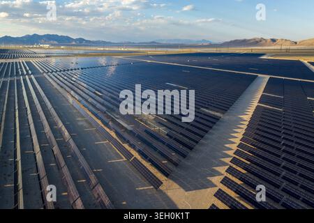 Luftaufnahme eines riesigen Solarpaneels, der sich über die Wüstenlandschaft mit Bergen unter blauem Himmel in Enterprise, Nevada, USA erstreckt. Stockfoto
