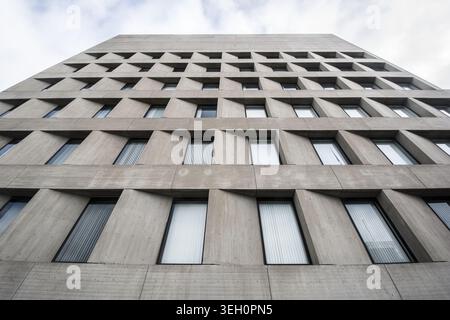 Blick auf die moderne Betonfassade eines Stadthauses mit einem sich wiederholenden geometrischen Fenstermuster unter einem bewölkten Himmel in Lincoln, Nebraska, Uni Stockfoto