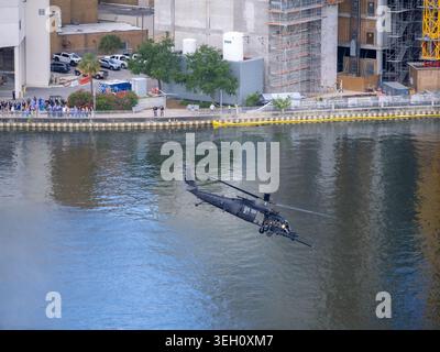 Tampa, FL, USA. Mai 2026. Ein MH-60 Black Hawk der US-Armee ragt tief über dem Garrison Channel, dessen Türschützer hinter einer berittenen Waffe als spe befestigt ist Stockfoto