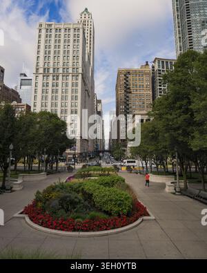 Chicago, USA - 15. September 2025: Blick auf historische Wolkenkratzer und üppige Blumenbeete entlang der Michigan Avenue unter blauem Himmel mit verstreuten cl Stockfoto