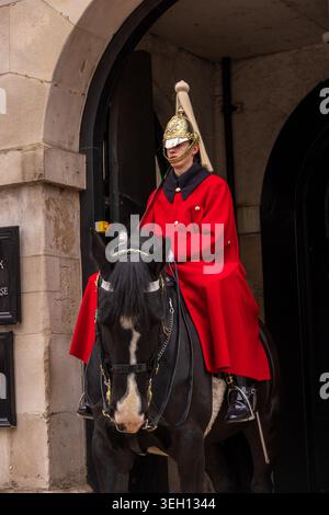 London, Vereinigtes Königreich - 12. Mai 2025: Ansicht eines Mitglieds der King's Life Guard in einem roten Mantel und einem zeremoniellen Helm auf einem schwarzen Pferd bei Horse Stockfoto