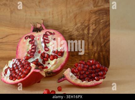 Offene Granatapfelfrucht auf Holzbrett Hintergrund, im horizontalen Format Stockfoto