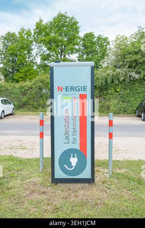 Roth, Deutschland, 05.17.2026 öffentliche Ladestation für Elektrofahrzeuge in der Nähe eines Parkplatzes oder Parkplatzes. Moderne Infrastruktur zum Aufladen von Batterien, grün Stockfoto