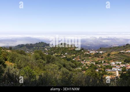 Weite Panoramalandschaft mit grünen Bergen und Wolkenschichten im Inneren von Gran Canaria, Kanarischen Inseln, Spanien. Stockfoto