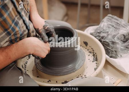 Nahaufnahme der Hände einer Frau, die einen Keramiktopf auf der Drehmaschine Formen Stockfoto