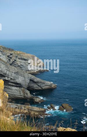 Malerisches Foto einer zerklüfteten Küste mit scharfen Klippen und tiefblauem Meer. Stockfoto