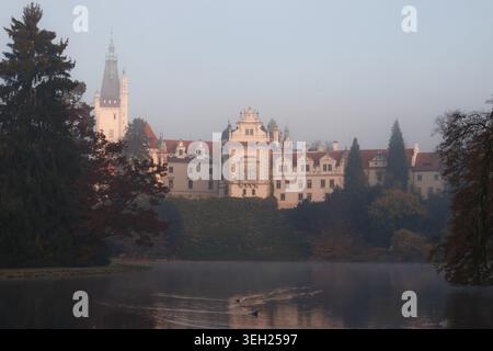 Das märchenhafte Schloss Pruhonice spiegelt sich an einem nebeligen Morgen in einem See Stockfoto