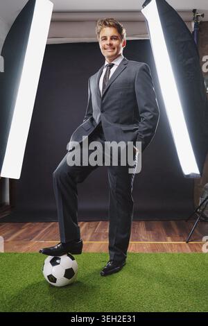 Ein sportlicher Mann in elegantem Anzug in einem professionellen Fotostudio - Coach- oder Profispieler-Konzept Stockfoto