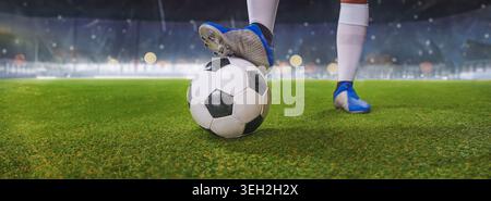 Füße des Fußballspielers treten auf den Fußball, um sich im sonnigen Stadion anzupfiffen. Stockfoto