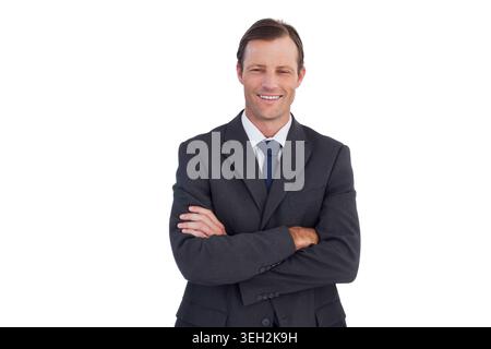 Reifer Mann posiert mit überkreuzten Armen im Studio, trägt Kohleanzug, weißes Hemd und marineblaue Krawatte Stockfoto