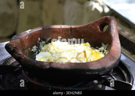Eier in einer traditionellen Terrakotta-Pfanne als Teil eines typischen rustikalen Frühstücks im Libanon gebraten. Stockfoto