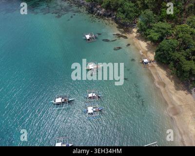 Blick von oben auf traditionelle Fischerboote in der Nähe des tropischen Strandes in Puerto Princesa, Palawan, Philippinen Stockfoto