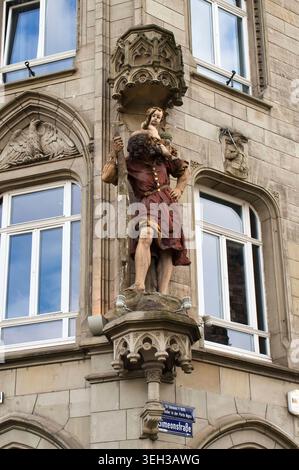 Trier, Deutschland - 15. Oktober 2021: Statue des Heiligen Christophorus, der das Christuskind über einen Fluss trägt, auf einem Gebäude in Trier. Stockfoto