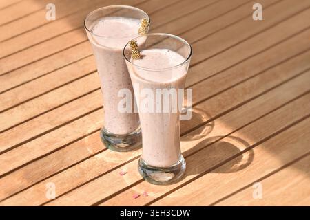 Gläser mit erfrischenden Beeren-Smoothies auf einem Holztisch Stockfoto