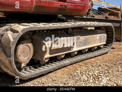 Nahaufnahme eines durchgehenden Gummilaufsystems an einem modernen Minibagger auf einer Baustelle. Stockfoto