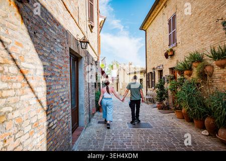 Paare gehen Hand in Hand durch das mittelalterliche Dorf Gradara Stockfoto