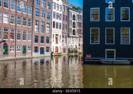 Amsterdam, Niederlande, 22.04.2026 - traditionelle Amsterdamer Grachtenhäuser mit Reflexionen auf dem Wasser Stockfoto
