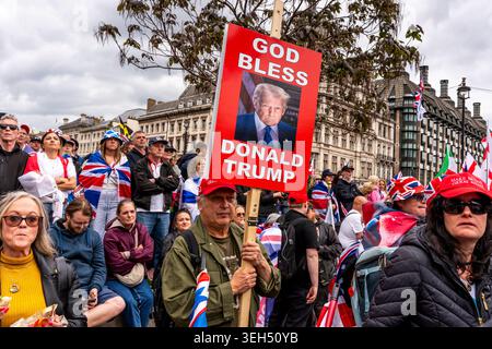 London, Großbritannien. Mai 2026. Ein Mann hält Ein Porträt von US-Präsident Donald Trump im Parlamentsgebäude auf. Während der Unite the Kingdom Rallye in London, Großbritannien Stockfoto