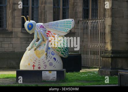 Farbenfrohe öffentliche Kunstskulptur eines Vogels vor einem modernen Stadtgebäude Stockfoto