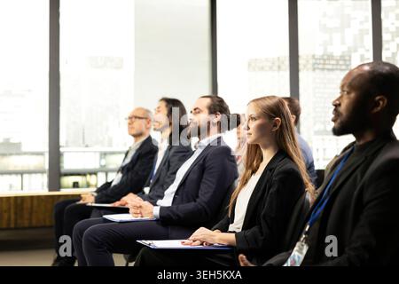 Verschiedene Teilnehmergruppen mit unterschiedlichen Altersgruppen lauschen während des Business Summit und nehmen gemeinsam an internationalen Veranstaltungen teil, um sich weiterzuentwickeln und zu vernetzen. Konferenzraum. Stockfoto