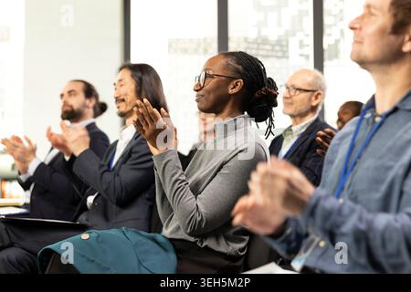 Business-Event im Konferenzraum mit Publikum klatschen die Hände und applaudierenden Rednern. Ein professioneller Referent hält Vorträge, während verschiedene Geschäftsleute an einer Firmenveranstaltung teilnehmen. Stockfoto