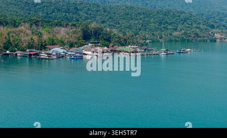 Koh chang Fischerdorf Häuser über klarem türkisfarbenem Meer mit üppiger tropischer Insel Stockfoto