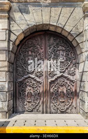 Kunstvoll geschnitzte antike Tür der Kirche San Agustin in Intramuros, Manila, Philippinen, die zum UNESCO-Weltkulturerbe gehört Stockfoto
