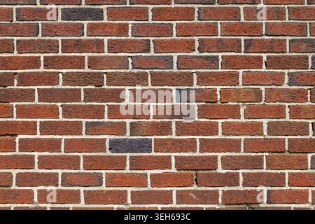 Vollrahmen-Nahstruktur einer roten Ziegelwand mit sichtbaren Mörtelfugen und verwitterten Oberflächendetails, geeignet als Architektur oder Konstruktion Stockfoto