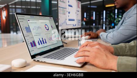 Zwei Finanzanalysten diskutieren über KPI-Dashboard-Einblicke zur Leistungssteigerung. Stockfoto