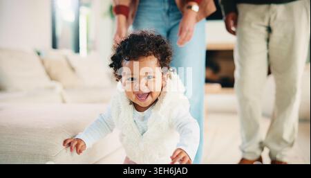Eltern, Walking oder Baby mit Porträt zu Hause, Kinderentwicklung oder begeistert für motorische Übungen. Familie, Kind oder glückliches Mädchen mit Lernen Stockfoto