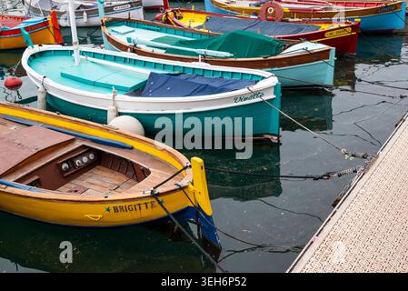 Nizza, Frankreich, 12. April 2026 traditionelle bunte Holzfischboote, die im ruhigen Mittelmeer von Port Lympia in Nizza, französische Riviera, vor Anker gebracht werden Stockfoto