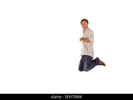 Der Mann springt mitten in der Luft auf einem nahtlosen weißen Hintergrund, trägt ein helles Hemd und dunkle Jeans, Kopierraum Stockfoto