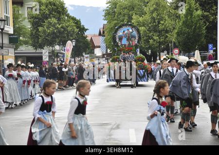 Straßenparade mit Mädchen in bayerischen Kostümen. Festliche Dekoration und Menschenmassen prägen das kulturelle Ereignis Gau Youth Pageant Stockfoto