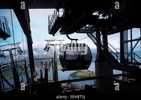Queenstown, Neuseeland: Skyline-Gondelwagen mit Passagieren kommt am Bahnsteig des Bergterminals an, Reise-Abenteuer über den Lake Wakatipu. Stockfoto