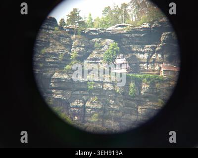 Das majestätische Pravcice Tor, der größte natürliche Sandsteinbogen Europas, die Böhmische Schweiz. Felsen und Bäume mit einem kleinen Haus auf einer Klippe, Stockfoto